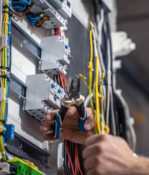 male-electrician-works-switchboard-with-electrical-connecting-cable (1) (1)